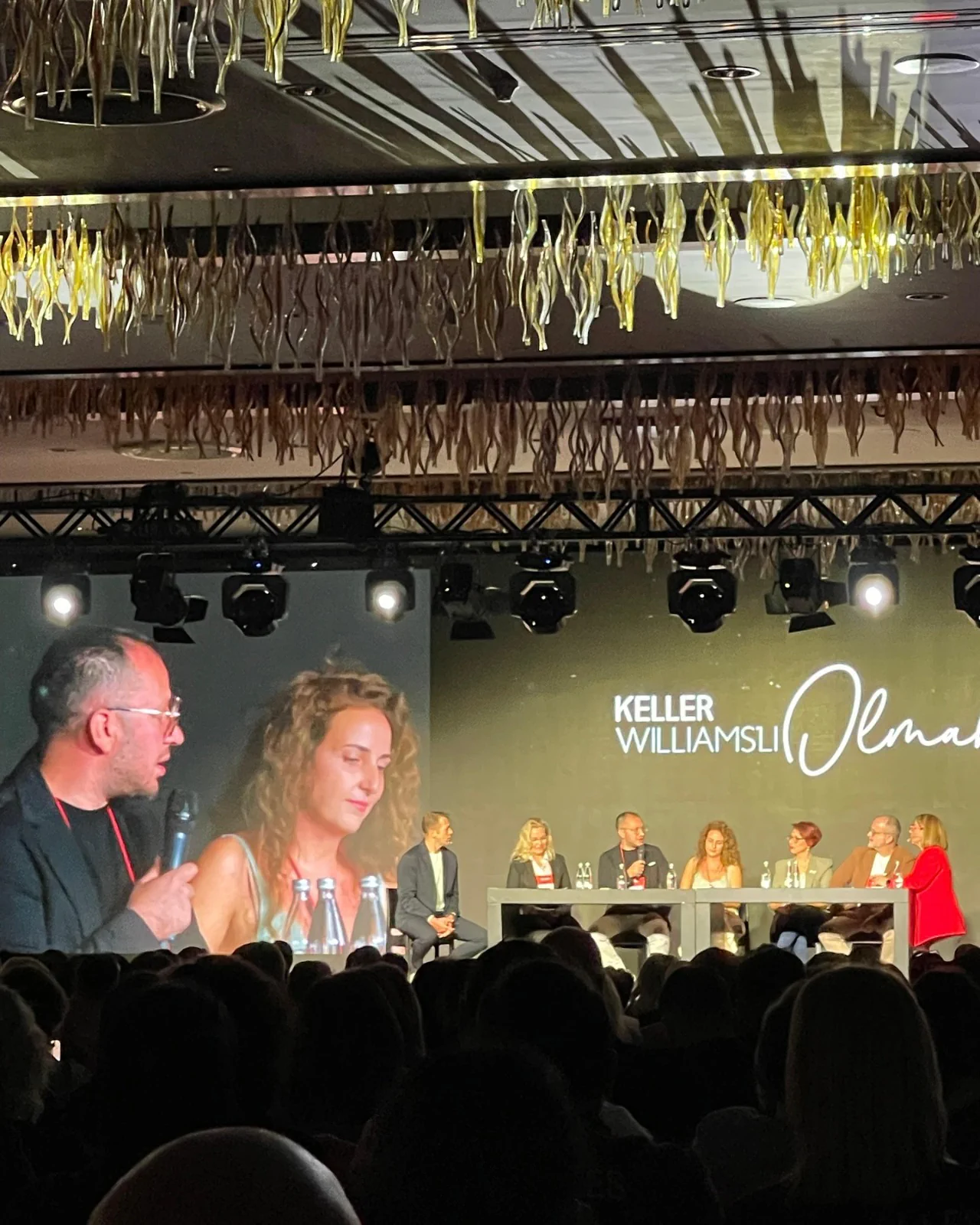 “Keller Williams’lı Olmak” paneli: sahnede konuşmacılar, önde dolu salon
